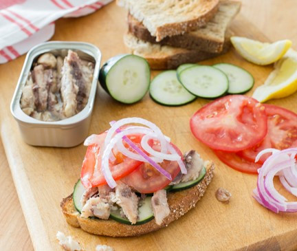 Sardine, Cucumber, and Tomato Sandwich on a cutting board