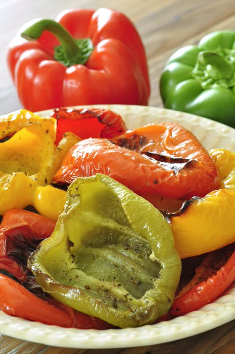 Red, yellow, and green roasted peppers on a plate