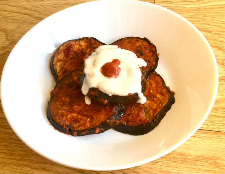 roasted eggplant topped with yogurt on a plate