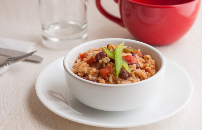 Small bowl of beans and rice with a green bell pepper ganish