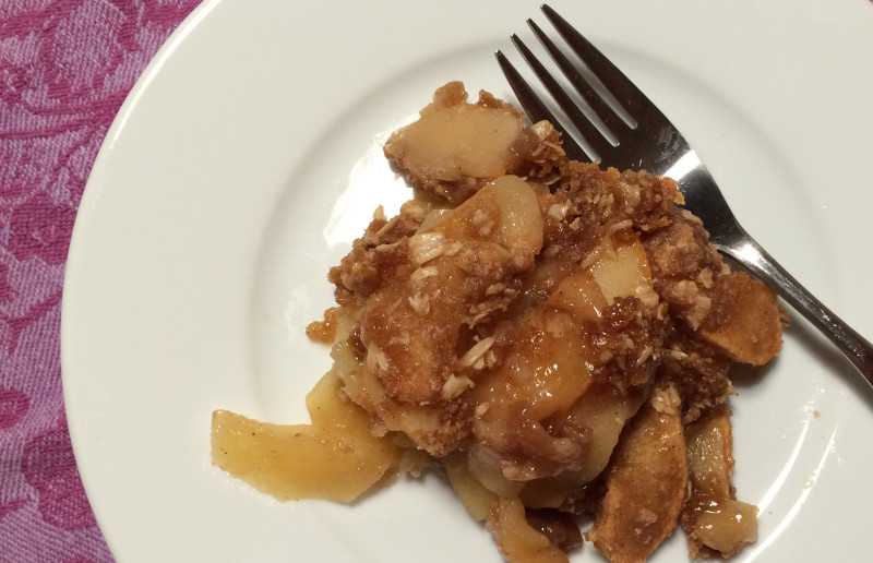 serving of apple crisp on a plate with a fork